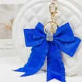 Blue ribbon bow keychain detail, featuring shiny rhinestones and pleated streamer design. - Style 11