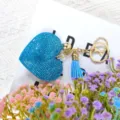 Porte-clés cœur en strass bleu avec quincaillerie dorée et pompon élégant vue de détail - Bleu