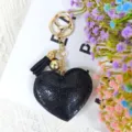 Détail du porte-clés cœur en strass étincelant avec ses cristaux noirs et son pompon élégant. - Noir