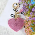 Porte-clés cœur en strass rose scintillant avec anneau doré et charm de sac à pompon. - Rose