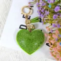 Porte-clés cœur en strass vert, vue de détail avec cristaux scintillants et pompon doré. - Vert
