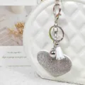 Porte-clés cœur en strass scintillant avec pompon blanc et fermoir métallique pour sacs à main. - Argent