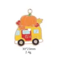 Detailed shot of an autumn pumpkin camper van enamel metal charm pendant accessory. - Car
