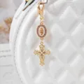 Gold alloy cross bag charm with rhinestones and faux pearls, elegant religious pendant style. - White