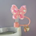 Dettaglio del copricanna a farfalla rosa paillettato con graziosi ciondoli a stella e cuore. - Stile 1