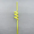 Detailed view of a bright yellow transparent plastic spiral straw with creative bending design. - Yellow