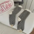 Vista di dettaglio calzini a righe bianche e nere, stile accademico classico per uso quotidiano. - Taglia unica / Beige