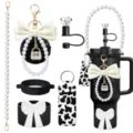 Close-up detail of tumbler accessories set featuring pearl strap, pompom and cow print. - Picture 27
