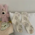 Cute dog pattern mid-tube socks in off-white with colorful flecks for casual cozy wear. - One Size / Many Puppies - Cream White