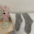 Cute grey crew socks for women featuring adorable puppy prints, casual and soft everyday wear. - One Size / Many Puppies - Gray