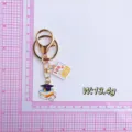 Graduation keychain detail showing metal cap books and full score test paper pendant close up - Book Doctoral Hat Keychain