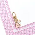 Joli porte-clés chat perlé rose avec pendentif petite fleur et fermoir mousqueton en métal. - Rose