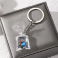 Close-up detail of the creative resin tropical fish water bag pendant keychain on pad. - Red Blue Fish