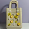 Dettaglio della borsa mare EVA beige con ciondoli di fiori gialli e perle eleganti. - Chiusura per borsa e borsa, giallo