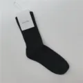 Chaussettes montantes en coton côtelé noir pour femmes avec étiquette de marque minimaliste. - Taille unique / Noir