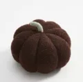 Close-up detail of the cozy brown plush pumpkin pillow, soft fuzzy texture and cute green stem. - Dark Coffee
