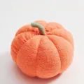 Gros plan détaillé sur le coussin moelleux en peluche citrouille orange avec tige verte. - 35cm / Orange