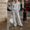 Vista dettagliata di una tuta casual grigio chiaro con mezza zip e pantaloni larghi. - Taglia S / Top e Pantaloni / Grigio