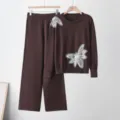 Gedetailleerd overzicht van de bruine gebreide trui set met elegante parel vlinder applicaties. - Eén maat / Top en Broek / Koffie