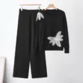 Gedetailleerd overzicht van zwarte gebreide set met strass vlinderapplicaties. - Eén maat / Top en Broek / Zwart