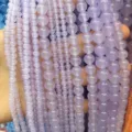Macro view of translucent natural lavender chalcedony round loose beads in various sizes - Light Purple Jade