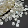 Close-up showing the iridescent texture of natural white mother of pearl cabochons - 4mm / White Mother of Pearl