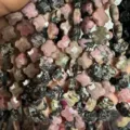 Macro view of 12mm faceted Rhodonite stone clover beads for DIY jewelry making projects. - Rhodonite