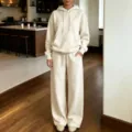 Vista dettagliata del comodo set loungewear beige con felpa con cappuccio e pantaloni larghi. - Albicocca