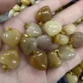 Detaillierte Ansicht von 16 mm herzförmigen Natursteinanhängern mit Goldösen - 16x9mm / Natürliche Gelbe Jade