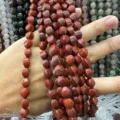 Gros plan de perles en pierre rouge naturelle torsadée pour la création de bijoux DIY - Jaspe Rouge