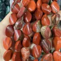Primo piano di perle sciolte ovali in diaspro rosso naturale per gioielli fai da te - Diaspro Rosso