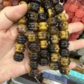 Close-up detail of natural tiger eye stone beads carved in a unique drum shape for DIY - Tiger's Eye