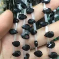 Vista macro detallada de cuentas de piedra natural negra facetada para joyería artesanal - 6x9mm (Aprox. 32 Piezas/Tira) / Ágata negra