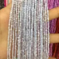 Close-up view of multiple strands of 2mm light blue round shell beads held in hand - 2mm (Approx. 38mm Strand) / Light Purple