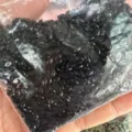 Primo piano di pietre naturali nere marquise da 2x4mm in un sacchetto di plastica - 2*4mm / Agata nera