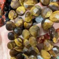 Close-up detail of faceted natural tiger eye heart-shaped beads for jewelry making - Heart / 13x13x6mm (Approx 27 Pcs/Strand) / Tiger Eye