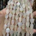 Macro detail of leaf-shaped natural white crystal beads for DIY jewelry making - 10x14x6 (15 Beads Per Strand) / Agate