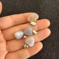 Detailansicht von 12 mm herzförmigen Natursteinanhängern in der Hand für Maßstab - 12x6mm / Grauer Achat