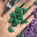 Gedetailleerde macro-opname van 20 mm groene maanvormige stenen met malachietpatroon in hand - 20x6mm / Malachiet-steen