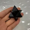 Detailansicht eines Merkaba-Stern-Ornaments aus schwarzem Naturstein in der Hand - 40mm / Schwarzer Achat