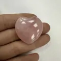 Nahaufnahme von glatt poliertem rosa Rosenquarz in Herzform als Naturstein-Kristalldekor - 20x6mm / Rosenquarz