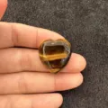 Vue rapprochée d'un cabochon en œil de tigre en forme de cœur avec des bandes jaunes - Beige / 10mm