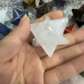 Hand mit einem klaren weißen Naturkristall-Merkaba-Stern für Meditation und Wohndekoration - 40mm / Weiß Kristall