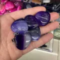 Close-up of hand holding purple striped agate heart jewelry pendants with silver bails - 25*6mm / Purple Agate