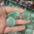 Close-up of green heart-shaped stone pendants with metal bails in hand - 25*6mm / Green Aventurine