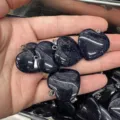 Polished heart-shaped blue sandstone pendants with sparkling mineral details in hand - 25*6mm / Blue Sandstone