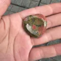 Nahaufnahme eines herzförmigen Unakitschmucksteins mit natürlichen grünen und rosa Mustern - Unakit / 30mm