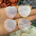Nahaufnahme von vier durchscheinenden herzförmigen Sorgensteinen für DIY-Schmuck - Opalith