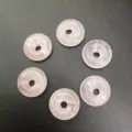 Close-up view of six 15mm natural pink stone Ping An Kou donut beads for jewelry making - 15mm / Rose Quartz