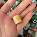 Macro view of 16mm yellow natural stone cylindrical large hole bead held in hand - Approx. 9*9mm / Topaz